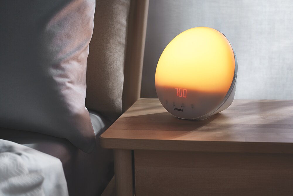 Philips SmartSleep HF3520/60 Wake-Up Light glowing on a bedside table