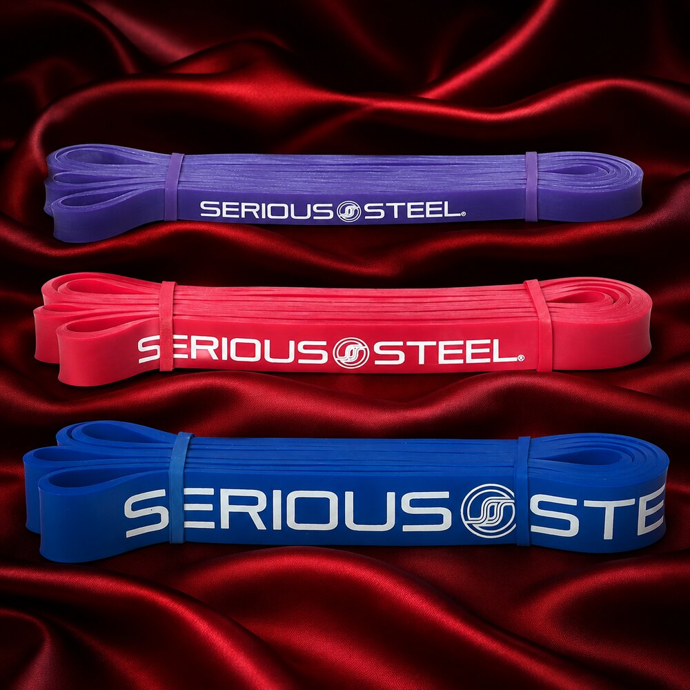 Purple, red, and blue Serious Steel 41-inch resistance bands displayed on deep red silk