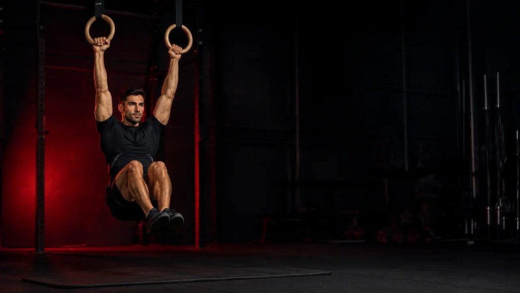 Athletic man training his core in a dark gym